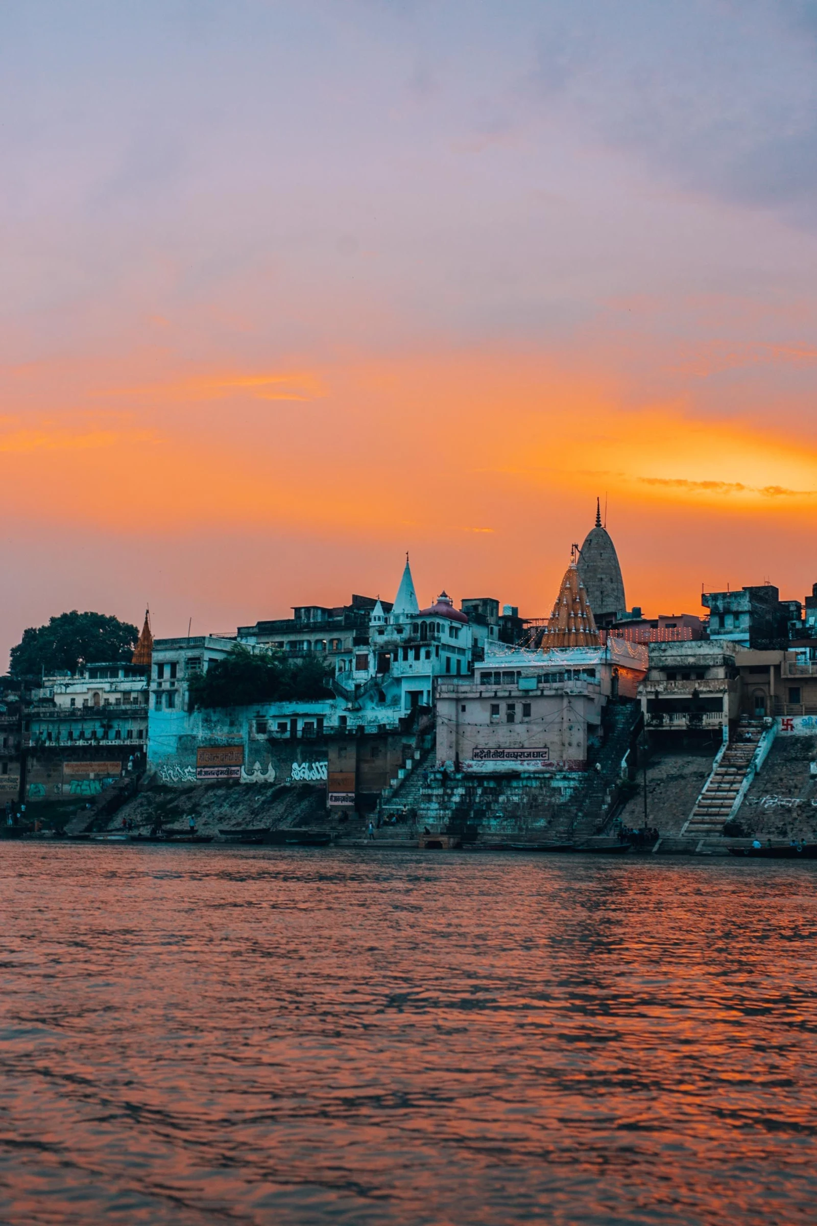 Varanasi ghat life, boats, temples and the Ganga at dusk