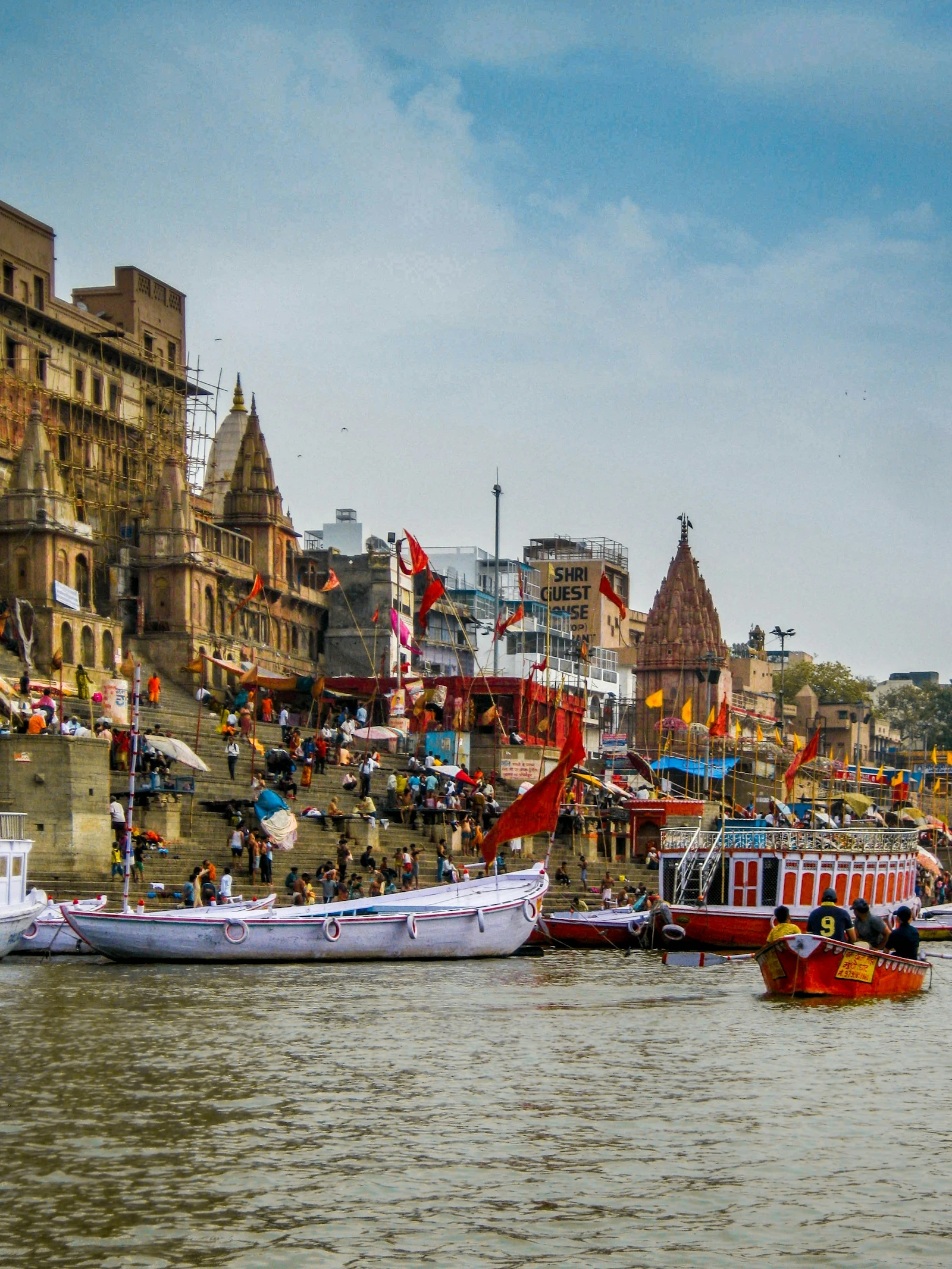 Wooden boats moored before the stone ghats and temples of Varanasi on the river Ganges at dawn