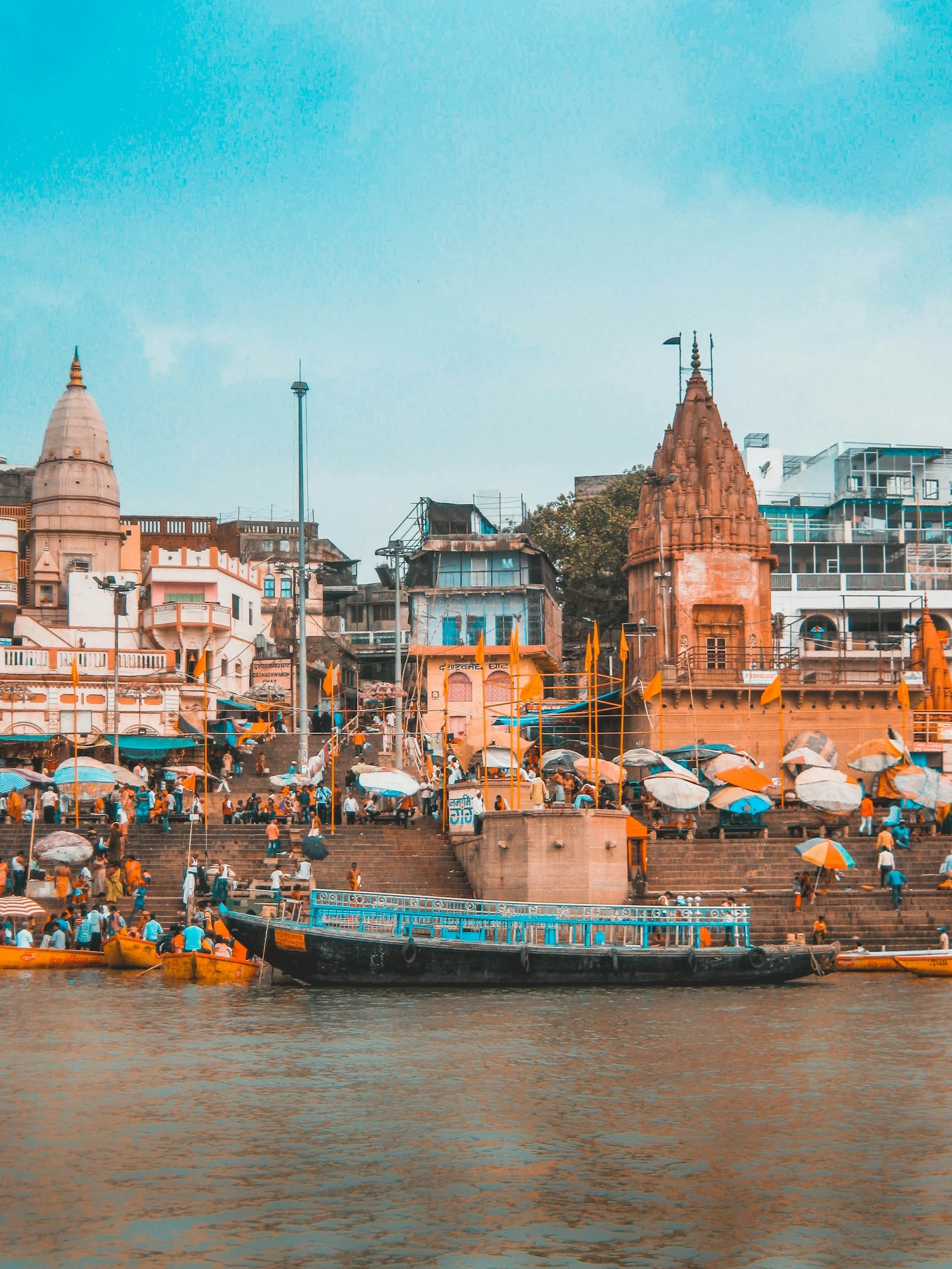 A rowing boat beside the stone ghats and riverfront buildings on the Ganges at Varanasi