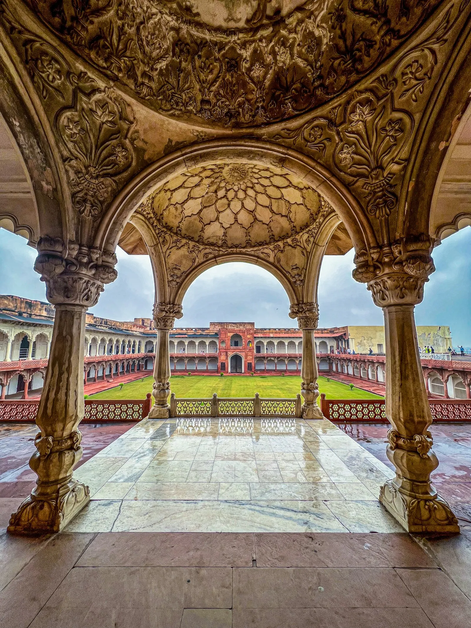 A carved sandstone archway framing a palace pavilion inside Agra Fort