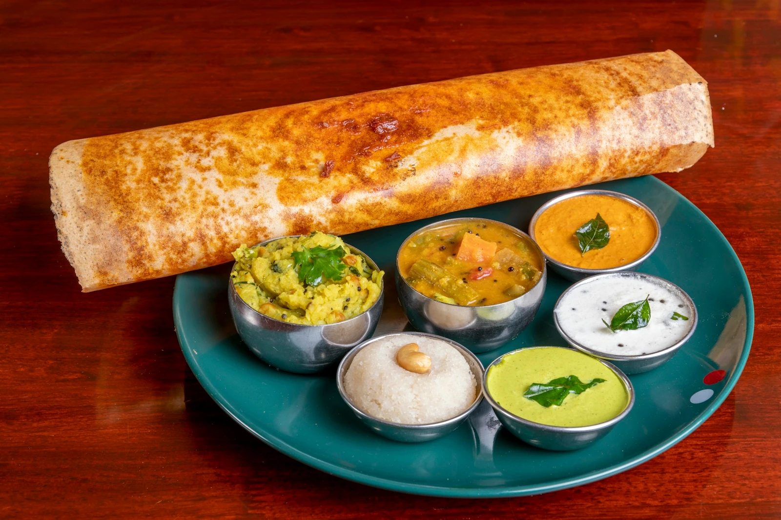 A crisp dosa served with potato masala, sambar and coconut chutney