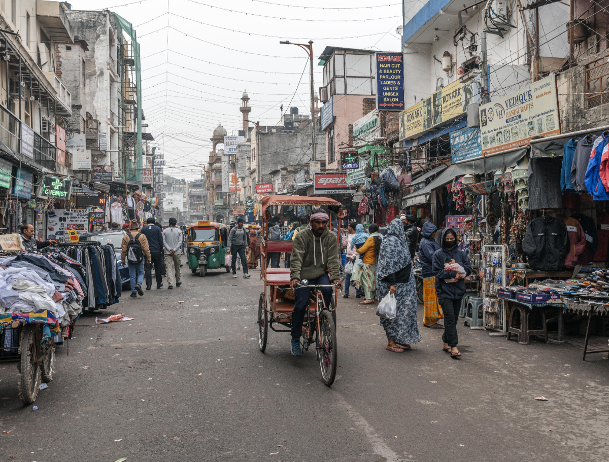 Cycle rickshaws and bicycles on a busy bazaar street