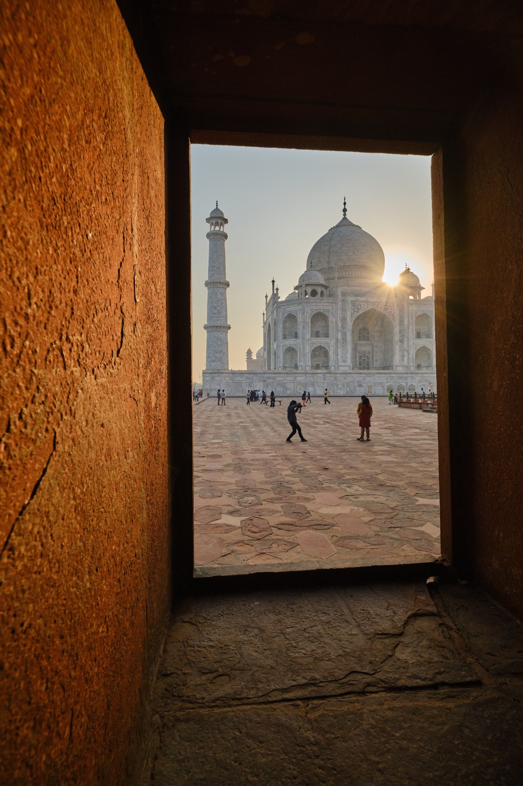 The Taj Mahal viewed through a sandstone window, golden afternoon light